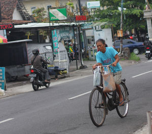Man riding bicycle on road in city