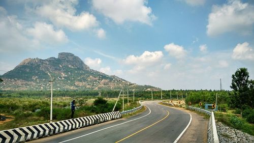 Empty road along landscape against sky