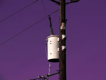 Low angle view of distribution transformer on power line