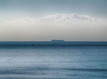 Scenic view of calm sea against cloudy sky