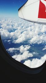 Cropped image of airplane flying over clouds