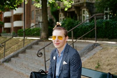 Portrait of man wearing sunglasses sitting on bench