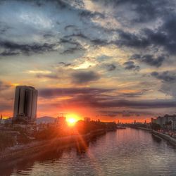 View of river against cloudy sky at sunset