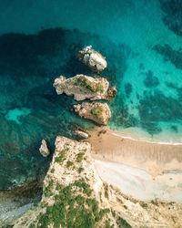 Aerial view of rocks at shore of beach