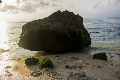 Rock formation on beach against sky