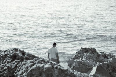 Rear view of man standing on rock