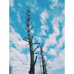 Low angle view of power lines against cloudy sky