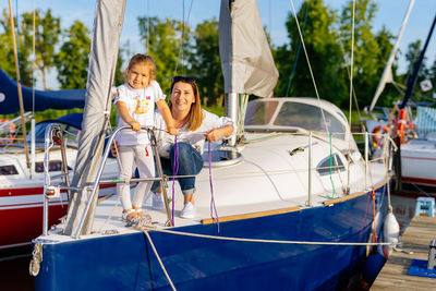 Portrait of mother and daughter sitting on boat
