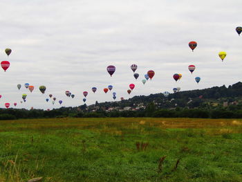 Hot air balloons flying over landscape against sky