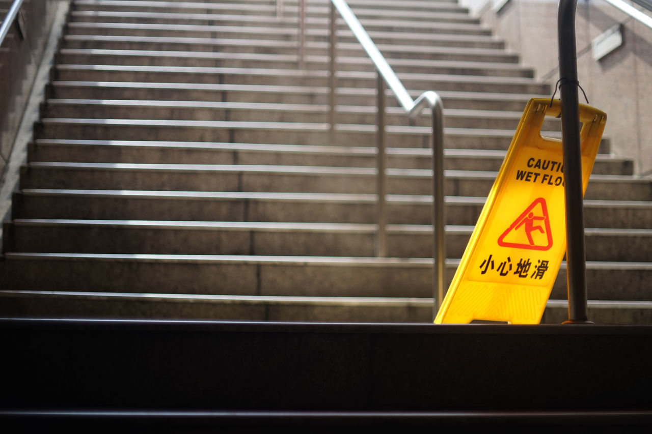 sign, communication, warning sign, text, staircase, yellow, western script, railing, no people, architecture, steps and staircases, metal, indoors, transportation, information sign, stairs, escalator, security, guidance, iron, transport