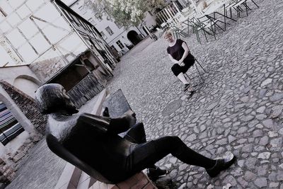 Woman looking at statue while sitting in city