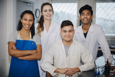 Portrait of confident young multi-ethnic engineering students in chemistry laboratory at university