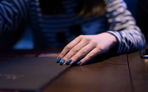 Midsection of woman sitting at table