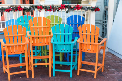 Empty chairs and tables in cafe against building