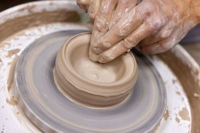 Cropped hand making pottery