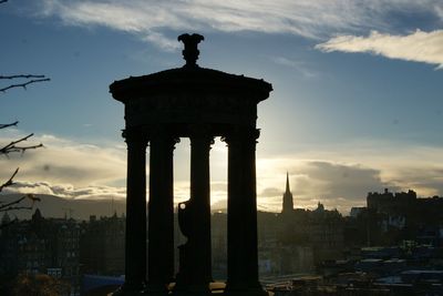 Silhouette city against sky during sunset