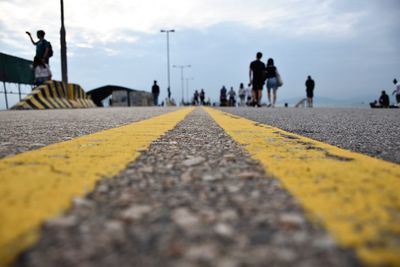 Surface level of yellow road against sky