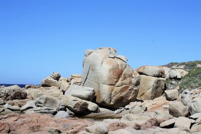 Low angle view of rock formations against clear blue sky