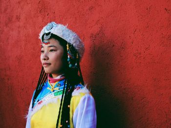 Portrait of young woman standing on wall