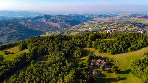 Aerial landscape of italian appennini hills with a little lake, trees, woods, meadows and fields
