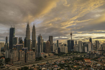 Aerial view of cityscape against cloudy sky