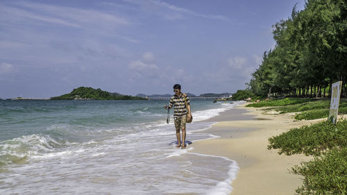 Man standing on beach against sky