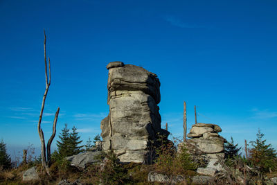 Low angle view of rocks against blue sky