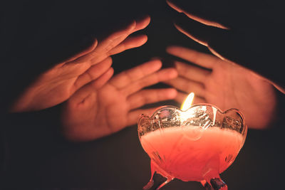 Close-up of hand holding lit candle