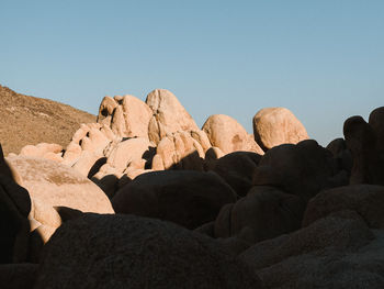Low angle view of rocks against clear sky