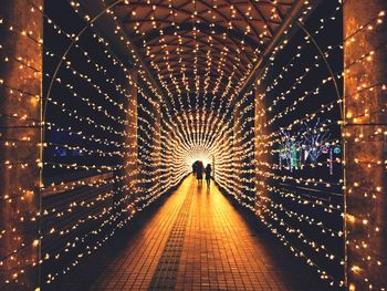 Illuminated christmas decorations at covered walkway