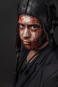 Close-up of man with face paint against black background