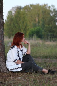 Full length of woman sitting on field