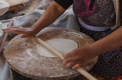 Midsection of woman rolling dough