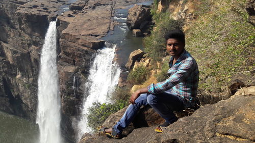 Full length of man looking at waterfall