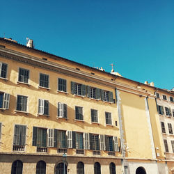 Low angle view of residential building against clear blue sky