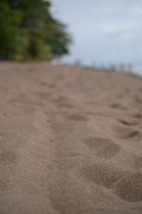 Close-up of sand at beach against sky