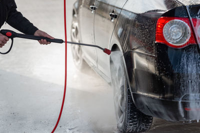 Cropped image of man washing car at garage