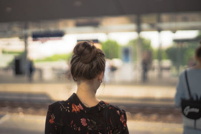 Rear view of woman standing in front of rail station