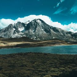 Scenic view of snowcapped mountains against blue sky