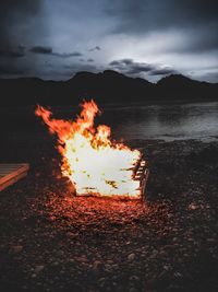 Bonfire on beach against sky at night