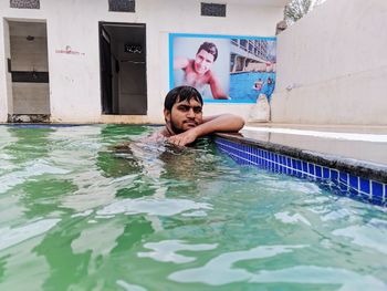 Portrait of shirtless man swimming in pool