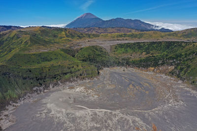 Scenic view of landscape and mountains against blue sky