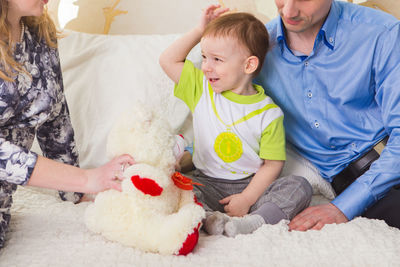 High angle view of friends sitting with toy