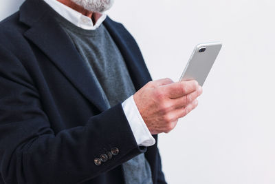 Midsection of man using mobile phone against white background