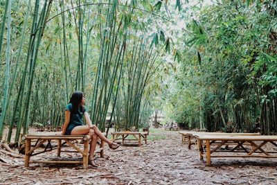 Young woman sitting on bench in park