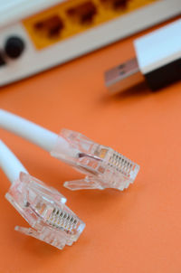 High angle view of network connection plugs on orange background