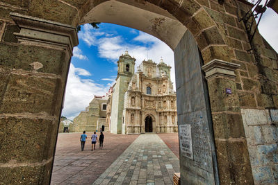 People in historic building against sky