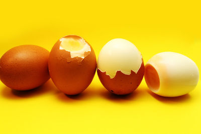 Close-up of broken eggs against yellow background