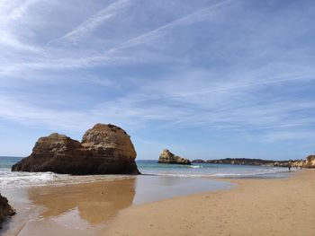 Rock formation on beach against sky