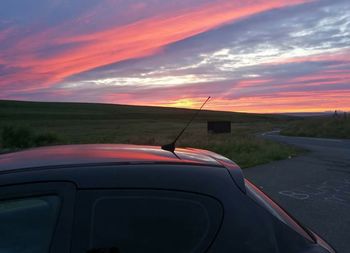 Close-up of car on road against sunset sky